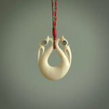This is a unique double manaia, pekapeka, handcarved bone pendant from cow bone. The cord is Red and Khaki and is length adjustable. This is delivered to you with Express Courier. The eyes are made from Paua shell.