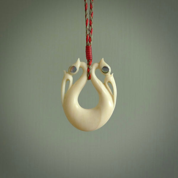 This is a unique double manaia, pekapeka, handcarved bone pendant from cow bone. The cord is Red and Khaki and is length adjustable. This is delivered to you with Express Courier. The eyes are made from Paua shell.