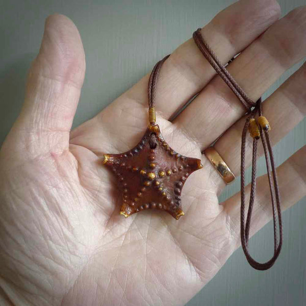 Hand carved bone starfish pendant. Ocean themed pendants carved by NZ Pacific. Moana pendants for sale online. Hand made stained bone sea star by Yuri Terenyi. We provide these starfish on adjustable brown or black cords. Postage is included in the price.