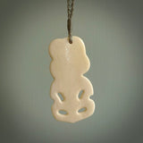 Hand carved bone Tiki pendant. Traditional art hand carved for NZ Pacific by Yuri Terenyi. Bone Tiki necklace with Paua Shell eyes.