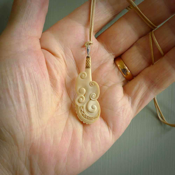 Hand carved engraved woolly mammoth tusk patu necklace hand made here in New Zealand. One only artistic patu pendant. Shipped to you with Express Courier. Stand out patu pendant for men and women. Mammoth tusk patu, art to wear.