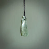 A hand carved curved contemporary drop pendant. This is a piece of genuine jade jewellery, hand carved by Raegan Bregmen. He has used rare New Zealand jade and has utilised his experience and carving skill to highlight the natural beauty of the stone. Delivered worldwide, postage is included in the price.