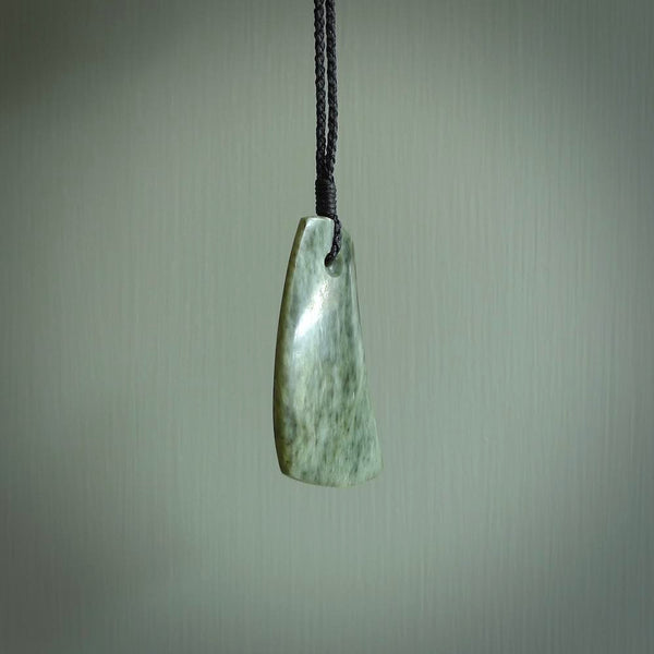 A hand carved curved contemporary drop pendant. This is a piece of genuine jade jewellery, hand carved by Raegan Bregmen. He has used rare New Zealand jade and has utilised his experience and carving skill to highlight the natural beauty of the stone. Delivered worldwide, postage is included in the price.