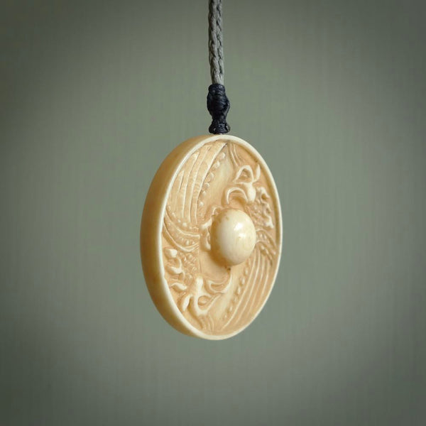 This piece is a hand carved contemporary bone shield pendant. Yuri Terenyi has carved this from Bone. It is a delightful, artistic piece of jewellery. One only necklace.