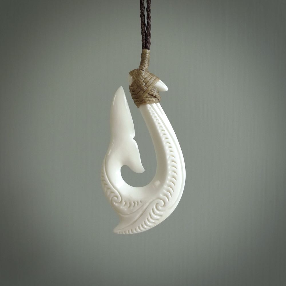 A handcarved hook pendant with a whaletail end. This is carved from bone and is detailed with a traditional Maori engraved design. We will ship this piece to you anywhere in the world and the price for shipping is included in the price. Unique bone jewellery for sale online at www.nzpacific.com