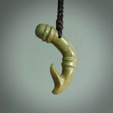 This photo shows a beautiful flower jade bamboo hook suspended from a hand plaited brown cord. The bamboo hook was carved for us by Jen Hung who is a master jade carver from New Zealand.