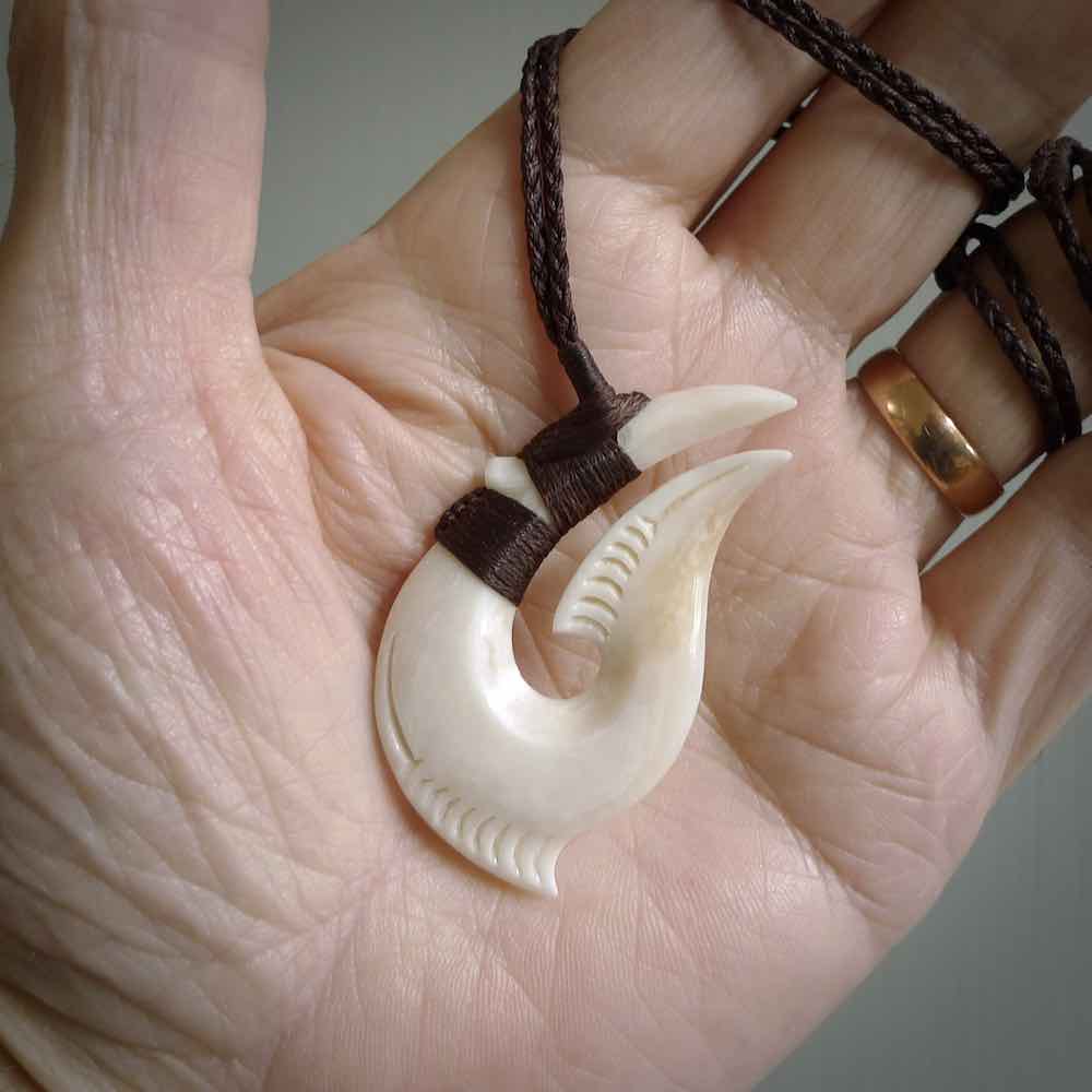 Hand carved cow bone hook pendant. Maori matau carving, hand carved jewellery for sale online.