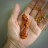 Hand carved stained bone female pendant in a repose shape with her cat. Made from natural bone. Bone jewellery from the Pacific for sale online. Female pendant for men and women.