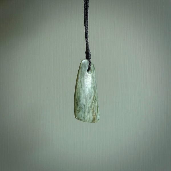 A hand carved curved contemporary drop pendant. This is a piece of genuine jade jewellery, hand carved by Raegan Bregmen. He has used rare New Zealand jade and has utilised his experience and carving skill to highlight the natural beauty of the stone. Delivered worldwide, postage is included in the price.