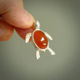 Fire Agate stone turtle in Sterling silver engraved casing. Hand carved jewellery made by NZ Pacific and for sale online. Moana, Ocean, jewellery hand carved in fire agate and Sterling Silver turtle necklace.