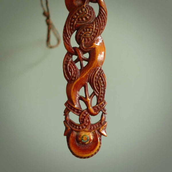 This necklace is carved from cow bone and stained with a homemade tea dye. It is a unique piece of wearable art that is sure to catch the eye. The shape is a complex twist form and has been beautifully hand carved by bone carver Yuri Terenyi.