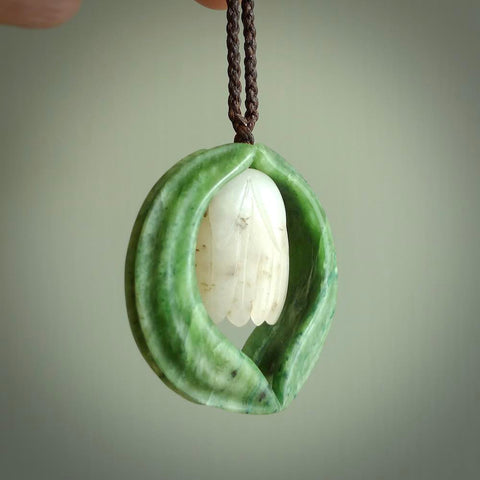 This photo shows a beautiful jade necklace with white siberian Jade. It is hand carved from jade and siberian jade. We have this on a brown coloured, adjustable cord. We ship this worldwide with an express courier service. Postage is free.