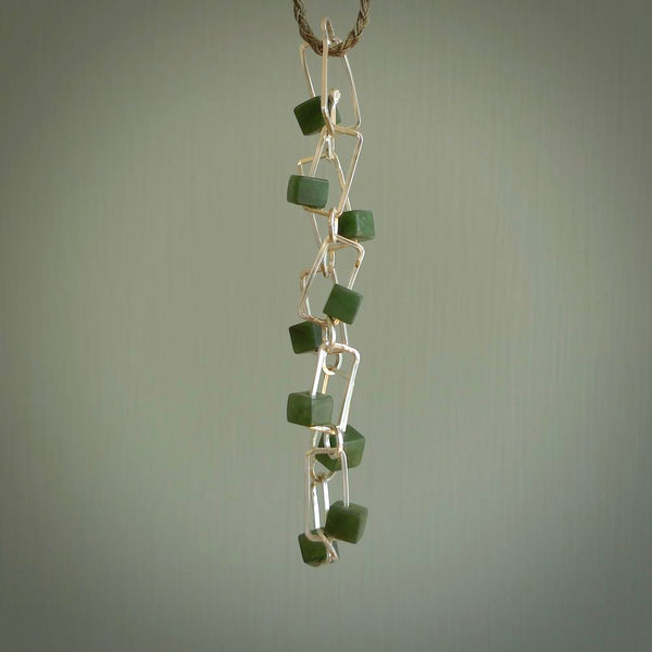 This bracelet is handmade from New Zealand Jade and sterling silver. It has a delicate cube of pounamu within each link of Sterling Silver chain and the Jade moves within each chain link.