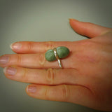 This is a handcrafted New Zealand Marsden jade squeezed ring with sterling silver. This is a solid little work of art. We ship this worldwide for free and are happy to answer any questions that you may have about these or other products on our website.