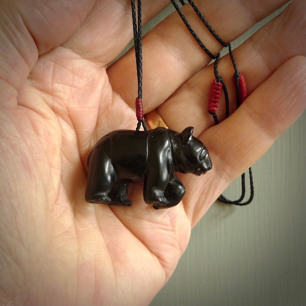 This picture shows a pendant that we designed in black jade. It is a little black bear that has a walking stance and is carved in detail. A really attractive and eye-catching piece of handmade jewellery. The cord is hand plaited braid in black and pale honey and the length can be adjusted.