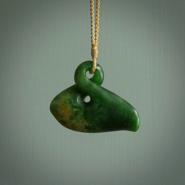 This piece is a medium, stylised drop shaped, single twist pendant. It was carved for us by Ric Moor from a lovely bright orange and green piece of New Zealand flower jade. It is suspended on an creme coloured braided cord that is length adjustable.