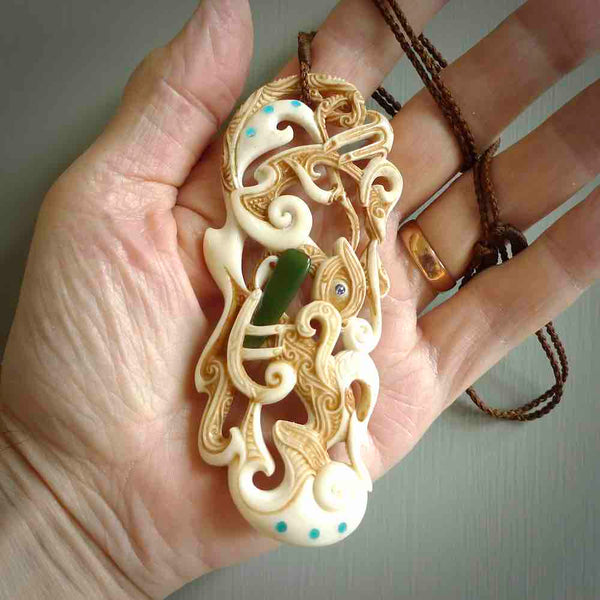 Hand carved bone manaia pendant. This is a complex carving by New Zealand carver and artist, Andrew Doughty. It is an intricate representation of a manaia carved to represent protection. It can be worn but is also a quality that warrants display.