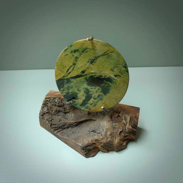 Hand carved New Zealand Flower Jade Disc with wooden stand sculpture. Hand carved here in New Zealand by Alex Sands Studio. This is a 'one only' sculpture, a beautiful display piece.