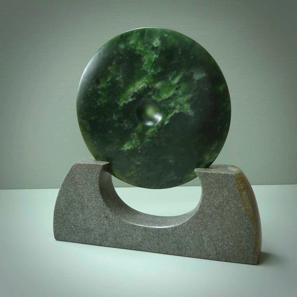 Hand carved New Zealand Marsden Jade Disc with Greywacke stand sculpture. Hand carved here in New Zealand by Ric Moor. This is a 'one only' sculpture, a beautiful display piece.