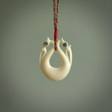 This is a unique double manaia, pekapeka, handcarved bone pendant from cow bone. The cord is Red and Khaki and is length adjustable. This is delivered to you with Express Courier. The eyes are made from Paua shell.