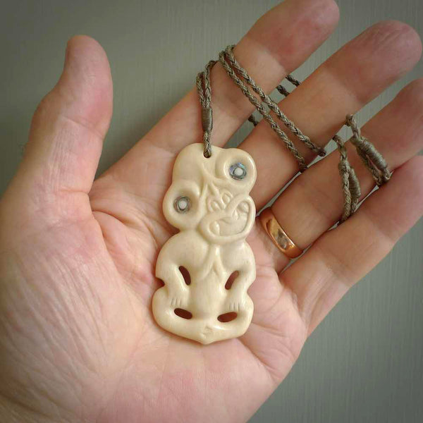 Hand carved bone Tiki pendant. Traditional art hand carved for NZ Pacific by Yuri Terenyi. Bone Tiki necklace with Paua Shell eyes.