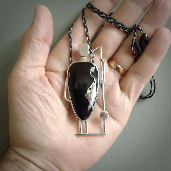 This is a very cool and creative fisherman hand made from Australian Black Jade and Sterling Silver. A fisherman who had caught a fish pendant hand crafted from sterling silver with Black Jade torso. A spectacular piece of art to wear.