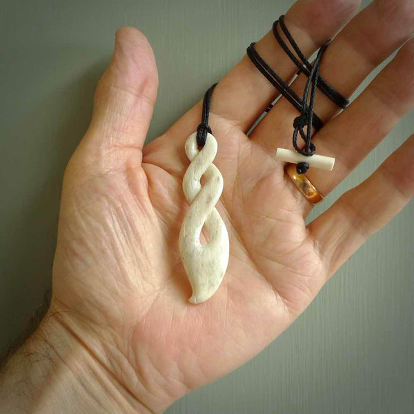 A hand carved twist design pendant from Whale Bone. The cord is black and adjustable in length. Large hand made twist necklace by New Zealand artist Kerry Thompson.
