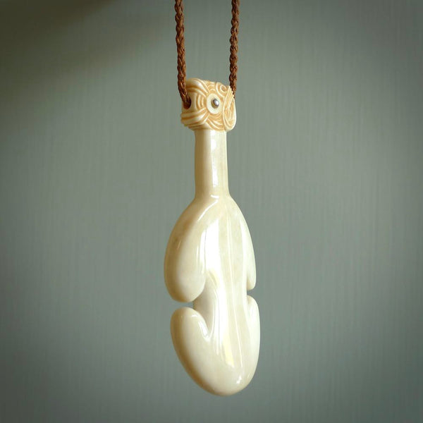 Hand carved engraved bone patu necklace hand made here in New Zealand. One only artistic patu pendant with hand plaited dark brown adjustable cord. Shipped to you with  Express Courier. Stand out patu pendant for men and women. Bone patu with Paua shell insert eyes.