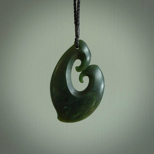 A hand carved large sized contemporary kour pendant. This is a piece of genuine jade jewellery, hand carved by Ric Moor. He has used New Zealand jade and has utilised his experience and carving skill to highlight the natural beauty of the stone. Delivered worldwide, postage is included in the price.