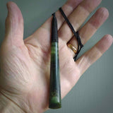 This photo shows a large jade drop shaped pendant. It a a lovely two-one green jade. Majority of this piece is a dark green colour with a semi-translucent top of the drop. The cord is black and is adjustable in length. Hand carved by Darren Hill.