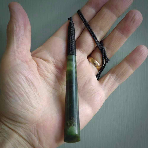 This photo shows a large jade drop shaped pendant. It a a lovely two-one green jade. Majority of this piece is a dark green colour with a semi-translucent top of the drop. The cord is black and is adjustable in length. Hand carved by Darren Hill.