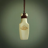 Hand carved engraved bone toki necklace hand made here in New Zealand. One only artistic toki pendant with hand plaited dark brown adjustable cord. Shipped to you with DHL Express Courier. Stand out toki pendant for men and women. Bone Toki with engraved NZ Pacific logo on the back and Paua shell insert on the front.