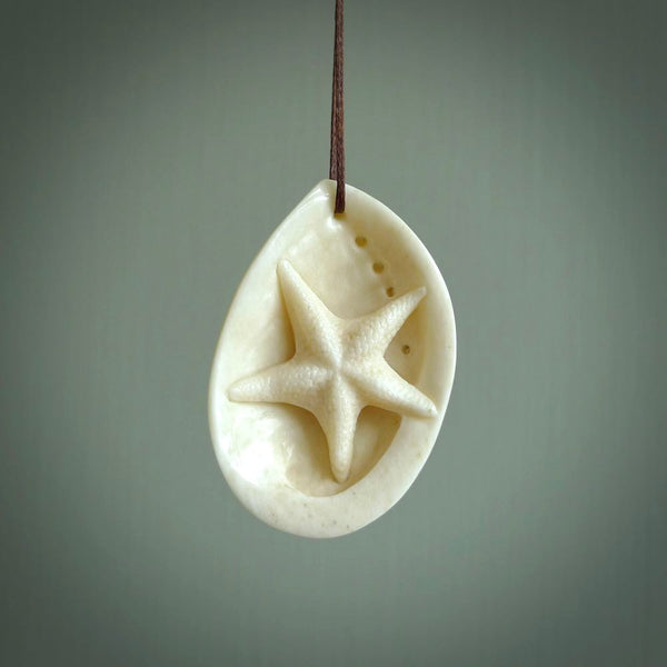 Hand carved bone paua shell with starfish inside pendant. Made from Bone in New Zealand. Unique Pāua Shell necklace hand made from bonoe with starfish carving inside the shell. Made by master bone carver Fumio Noguchi. Spectacular collectable work of art, made to wear. One only pendant, delivered to you at no extra cost with express courier.