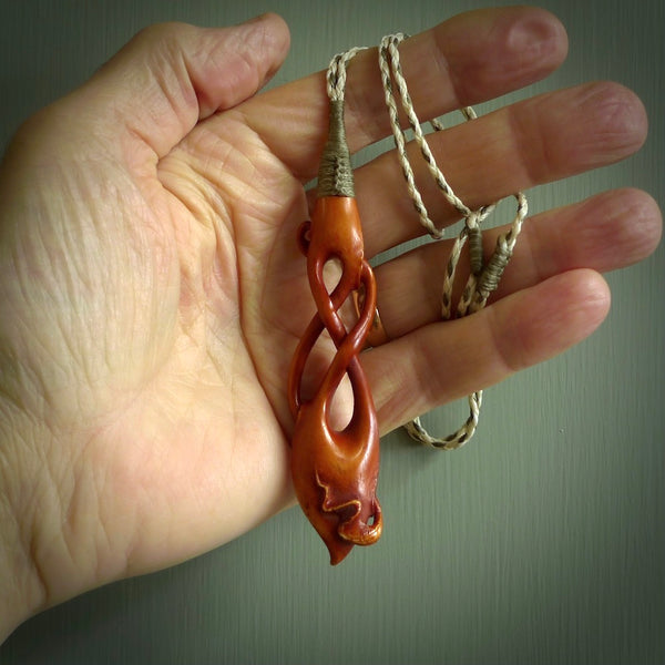 This pendant is carved from cow bone and stained with a homemade tea dye. It is a unique piece of wearable art that is sure to catch the eye. The shape is a complex twist form and has been beautifully hand carved by bone carver Yuri Terenyi.