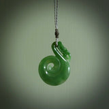 Hand carved medium sized Inanga jade manaia with koru pendant. Made for NZ Pacific by Ross Crump. We will ship this to you with an express courier service. This is a one-off piece and is collectable. A gorgeous pendant!