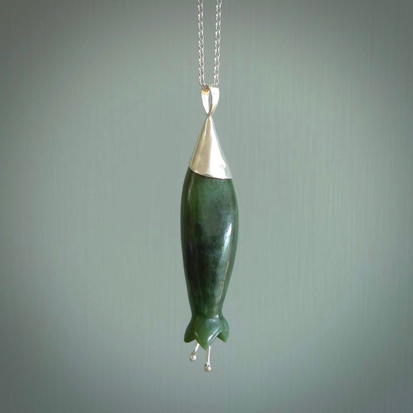 A photo of a harakeke, or flax flower, carved from a colourful piece of New Zealand flower jade. The cap and stamens are made from Sterling Silver and the cord is an Olive braid which is length adjustable.