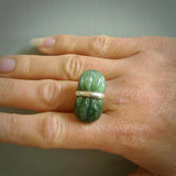 This is a handcrafted New Zealand Marsden jade squeezed ring with sterling silver. This is a solid little work of art. We ship this worldwide for free and are happy to answer any questions that you may have about these or other products on our website.