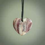A hand carved heart pendant made from New Zealand Rhodonite Stone. This is a medium sized and visually striking piece, beautifully curved and sensuous. The perfect piece of jewellery for someone you love.