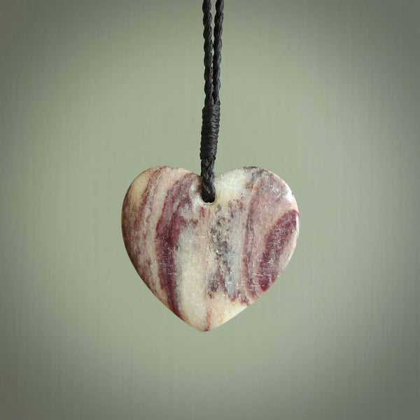 A hand carved heart pendant made from New Zealand Rhodonite Stone. This is a medium sized and visually striking piece, beautifully curved and sensuous. The perfect piece of jewellery for someone you love.