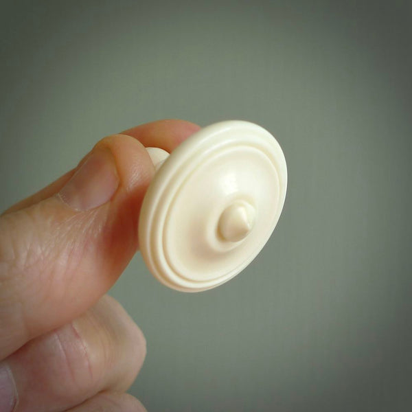 A traditional hand carved bone spinning top toy. This piece is made from bone and is a fully functioning toy that can be played with. Beautiful, contemporary art hand made by NZ Pacific.