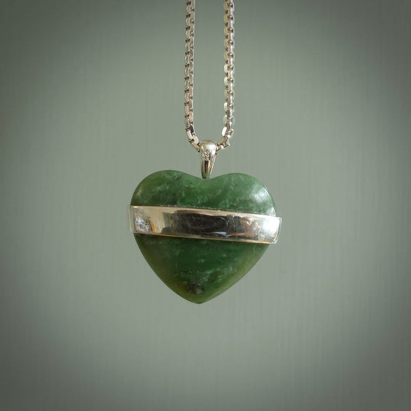 Hand crafted New Zealand jade love heart necklace. This piece has  a sterling silver love written across its' body. This necklace is provided with a sterling silver chain.