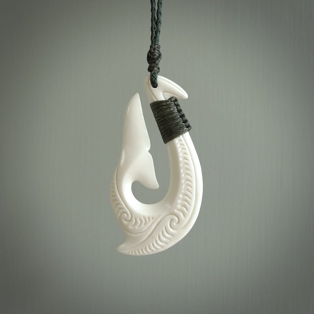 A handcarved hook pendant with a whaletail end. This is carved from bone and is detailed with a traditional Maori engraved design. We will ship this piece to you anywhere in the world and the price for shipping is included in the price. Unique bone jewellery for sale online at www.nzpacific.com