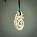 This is a unique manaia with koru, hand carved natural bone pendant with Paua Shell eyes. The cord is Black and is length adjustable. This is delivered to you with Express Courier. The eyes are made from Paua shell.