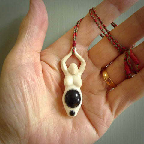 Hand carved womanhood pendant from Natural Bone with Black Jade insert. The Australian Black Jade insert represents a woman's womb. Hand made, unique necklace to empower women. This pendant is provided on a hand plaited, adjustable cord. Shipping is included in the price.
