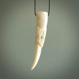 A mythical bird head hand carved from bone with Paua shell eyes. This is a one only bird head with long beak necklace hand made from natural bone with paua shell eyes. This bird head has engravings and is a magnificent piece of art to wear. It is delivered on a black adjustable cord.