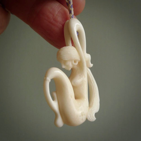 This pendant is a gorgeous and intricately carved mermaid pendant. Carved by renowned bone carver Yuri Terenyi for us. This is a little masterpiece. It is a mermaid with her arms clasped around her tail. The craftsmanship displayed in this piece is extraordinary - a collectors item, or a piece to wear and love.