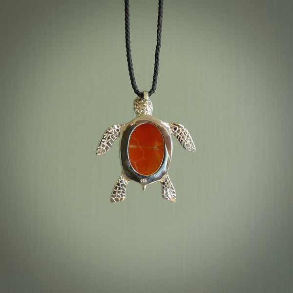 Fire Agate stone turtle in Sterling silver engraved casing. Hand carved jewellery made by NZ Pacific and for sale online. Moana, Ocean, jewellery hand carved in fire agate and Sterling Silver turtle necklace.