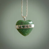 Hand crafted New Zealand jade love heart necklace. This piece has  a sterling silver love written across its' body. This necklace is provided with a sterling silver chain.