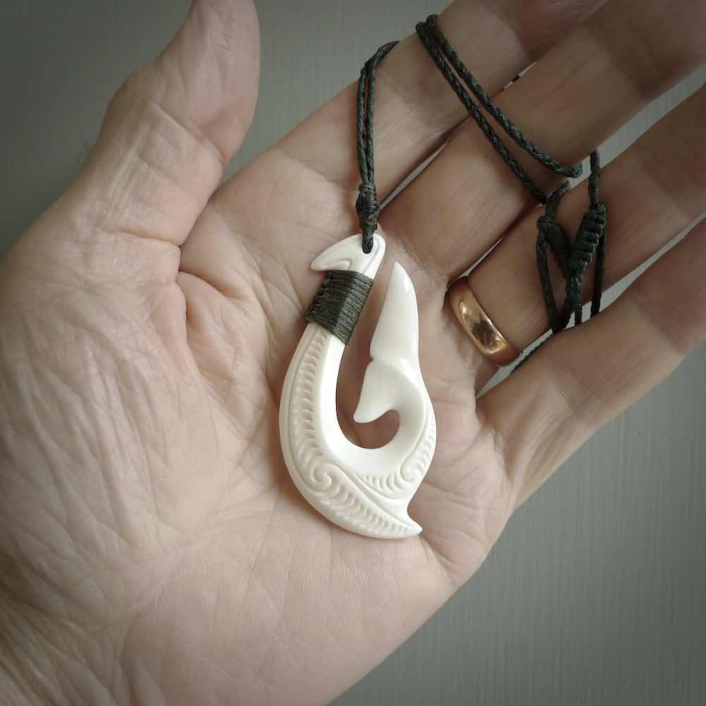 A handcarved hook pendant with a whaletail end. This is carved from bone and is detailed with a traditional Maori engraved design. We will ship this piece to you anywhere in the world and the price for shipping is included in the price. Unique bone jewellery for sale online at www.nzpacific.com