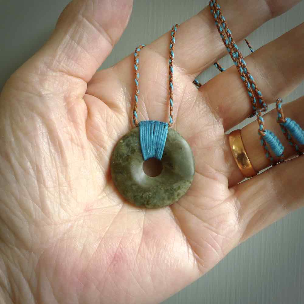 These are medium sized pendants - very finely carved. They are New Zealand Jade discs with a centre hole. It is suspended from a cord which is adjustable. These are beautiful pieces of expressive jade jewellery. Unique New Zealand made pendants for men and women. Perfect gifts for all.